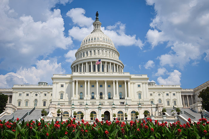 US Capitol Building against blue sky with clouds