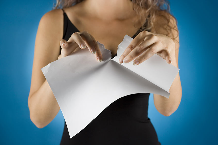 Photo of a woman tearing up a piece of paper