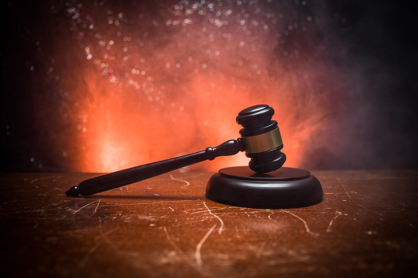 Photo of a gavel with coral colored lighting in background