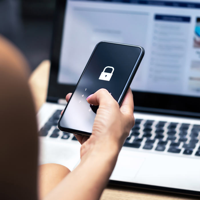 Photo of a woman entering a password on her phone